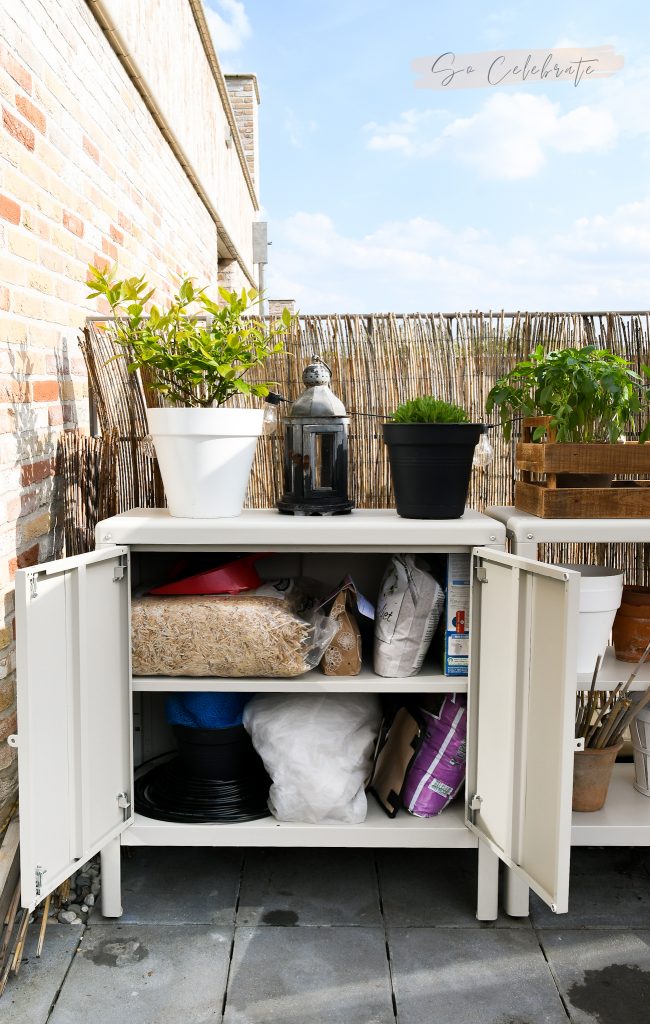 IKEA Kolbjorn kastje voor buiten met de deurtjes open en moestuin materialen erin